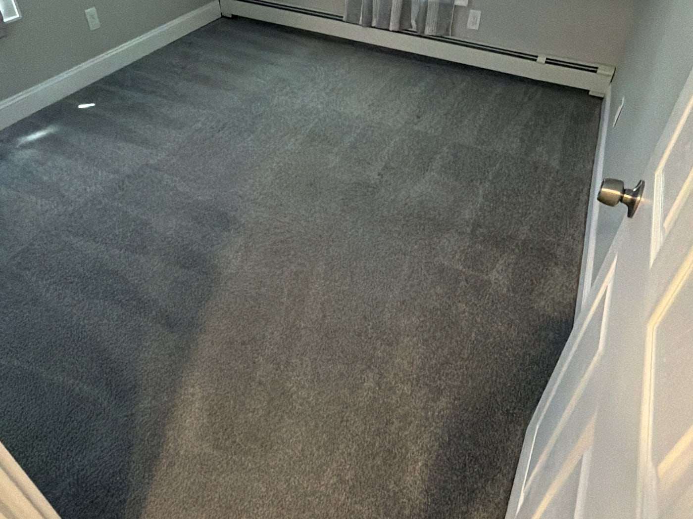 A grey bedroom carpet after cleaning, the room empty and ready for use