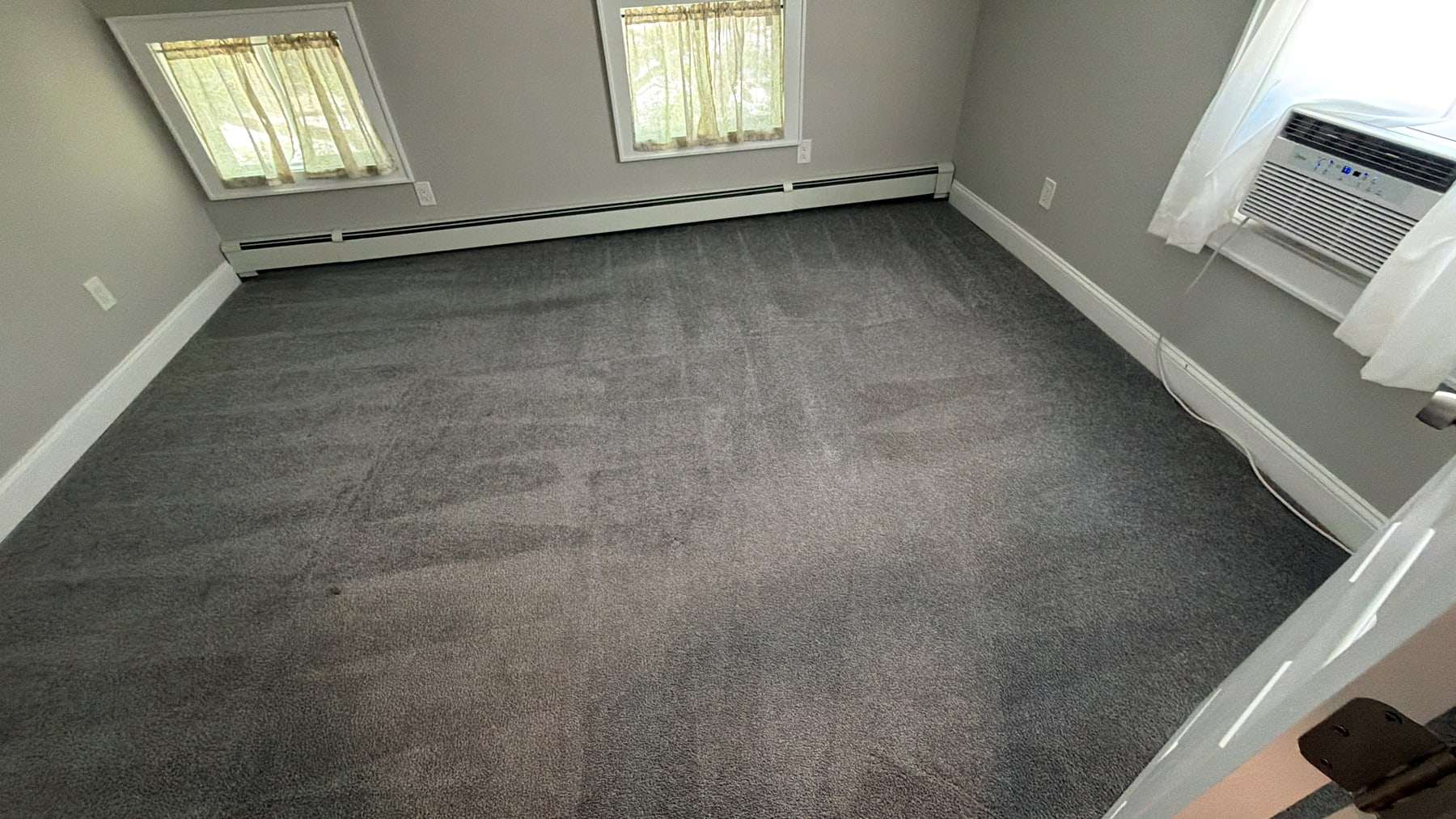 A bedroom carpet after cleaning, extraction lines running across the grey pile