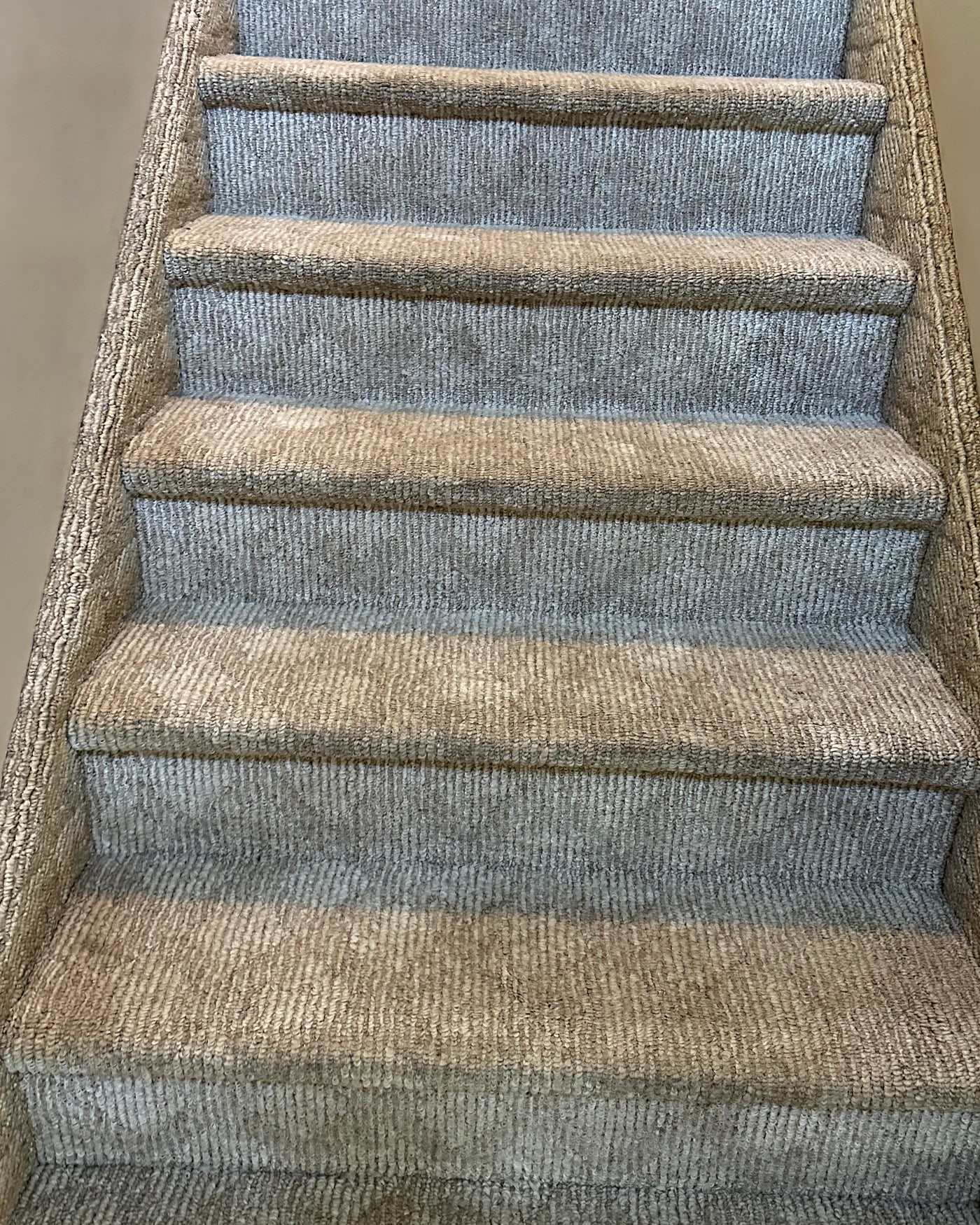 The same carpeted stairs after cleaning, the oatmeal and blue-grey banding even again