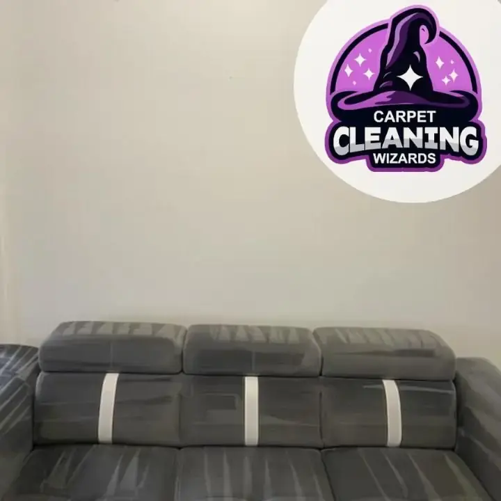 Fabric sofa halfway through cleaning, the cleaned band visibly lighter, by Carpet Cleaning Wizards