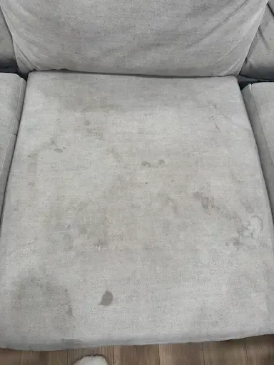 A fabric sofa before cleaning, soiled and dulled