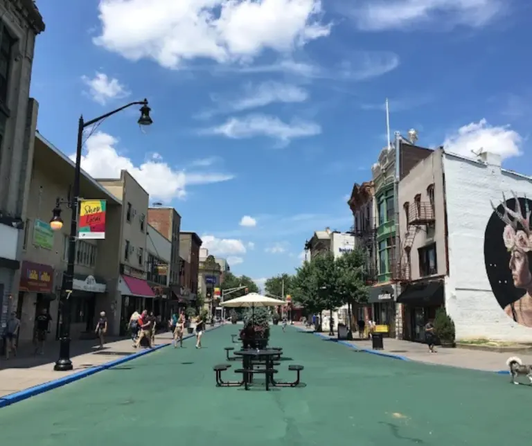 Bustling scene of Newark Avenue’s Pedestrian Plaza in Downtown Jersey City, filled with outdoor dining, local shops, and visitors enjoying the car-free zone.